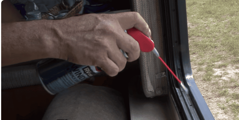 Applying-Lubricant-To-RV-Window-Track.jpg A person's hands applying WD-40 lubricant to the track of an RV window.