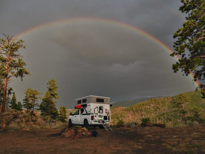 Top 7 Amazing Truck Campers For The Toyota Tacoma 7 Phoenix Mini-Max pop-up truck camper with a wet bath under a rainbow